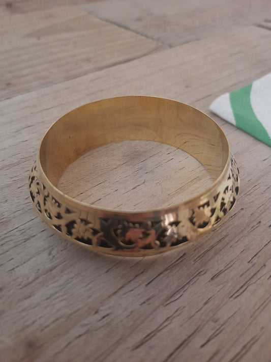 Gold-coloured floral bangle with green velvet lining