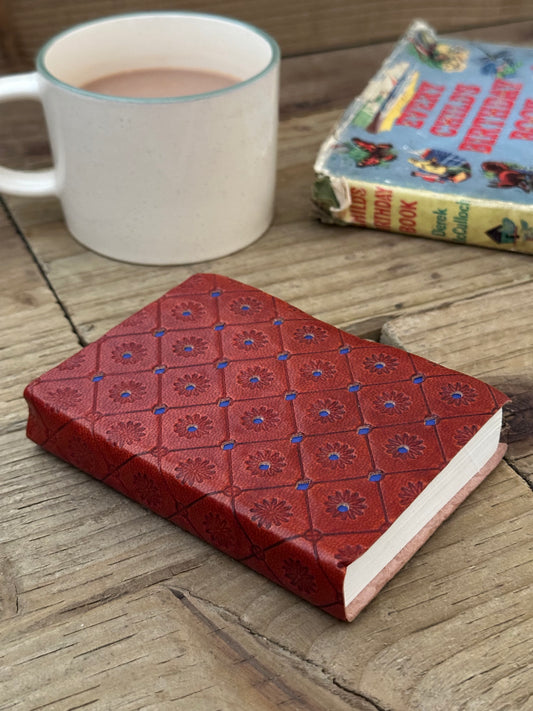 Close-up of the embossed blue leather cover on a mini notebook