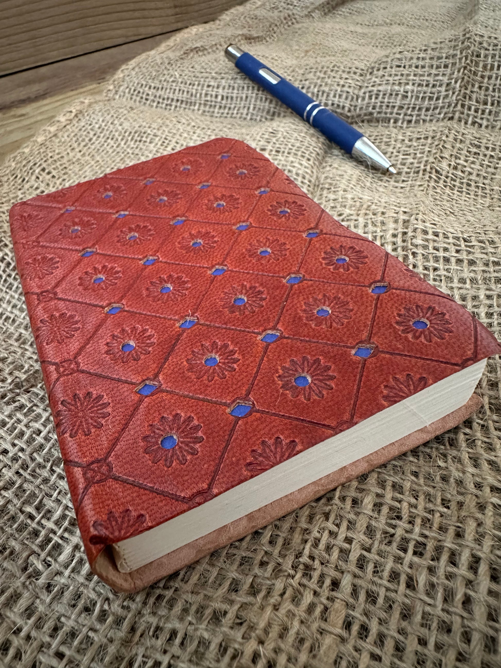 Compact blue leather notebook with decorative embossed cover