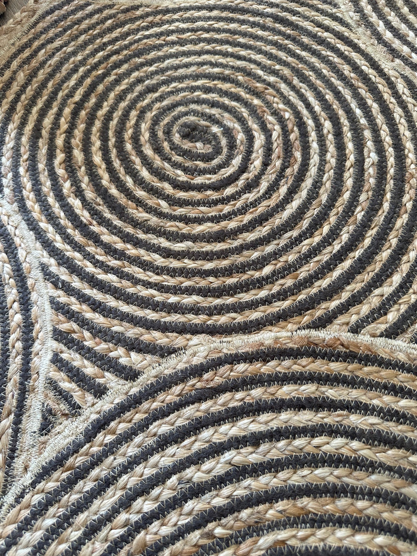 Close view of swirling brown jute rug pattern