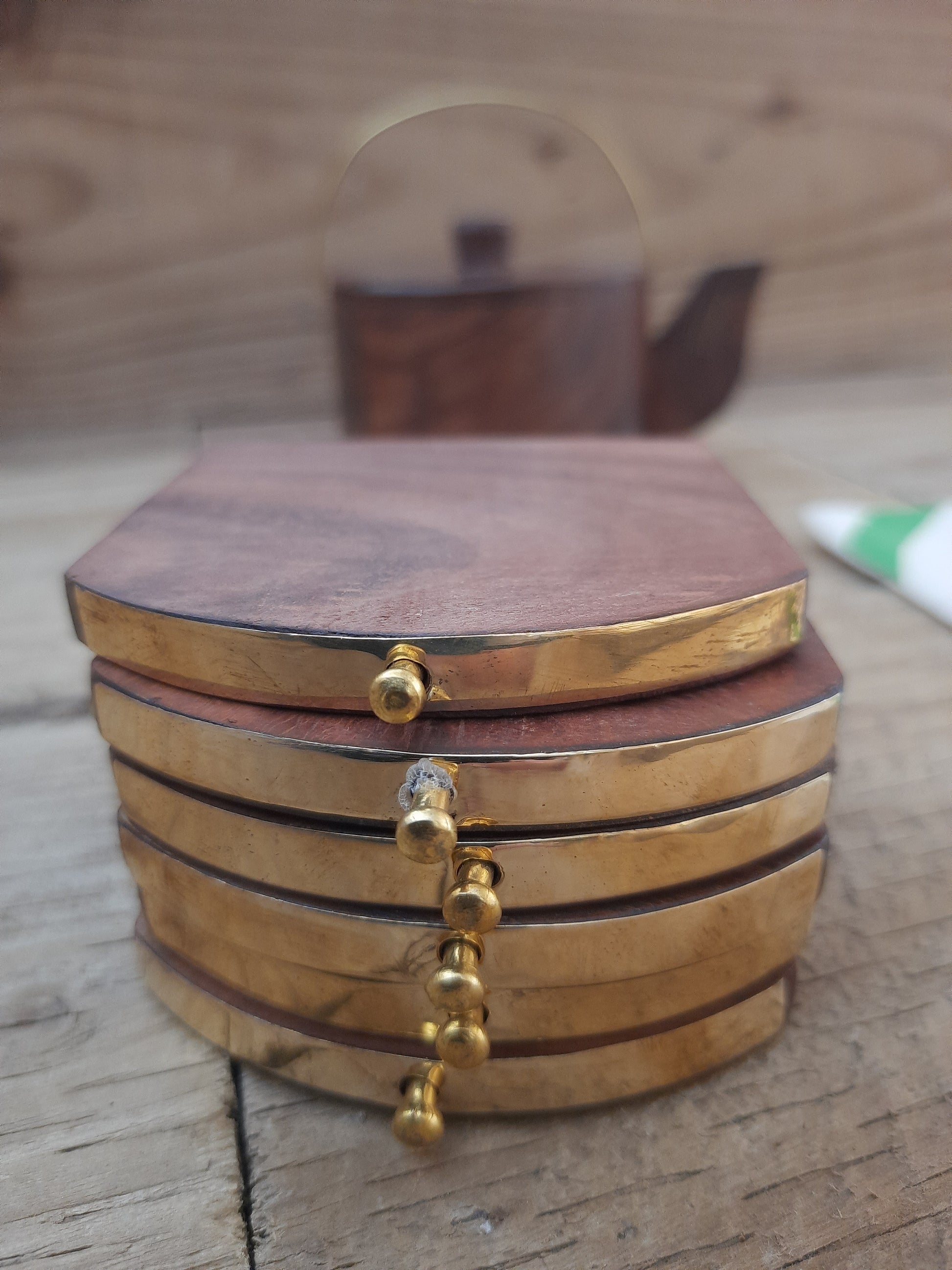 Wooden tea coasters displayed in kettle-shaped caddy
