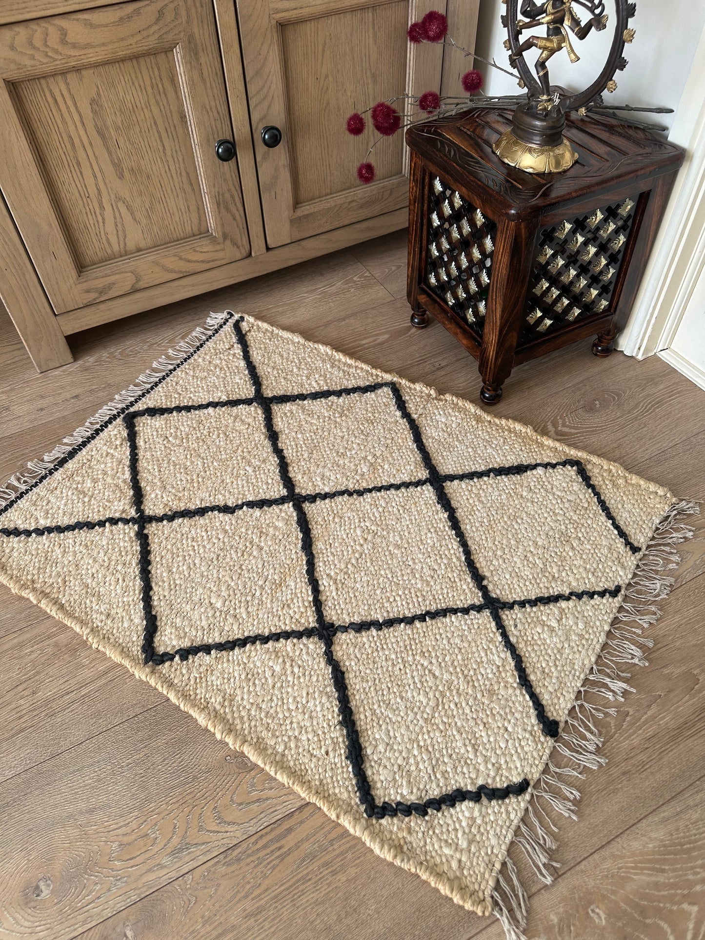 White woven jute rug with bold black diamonds