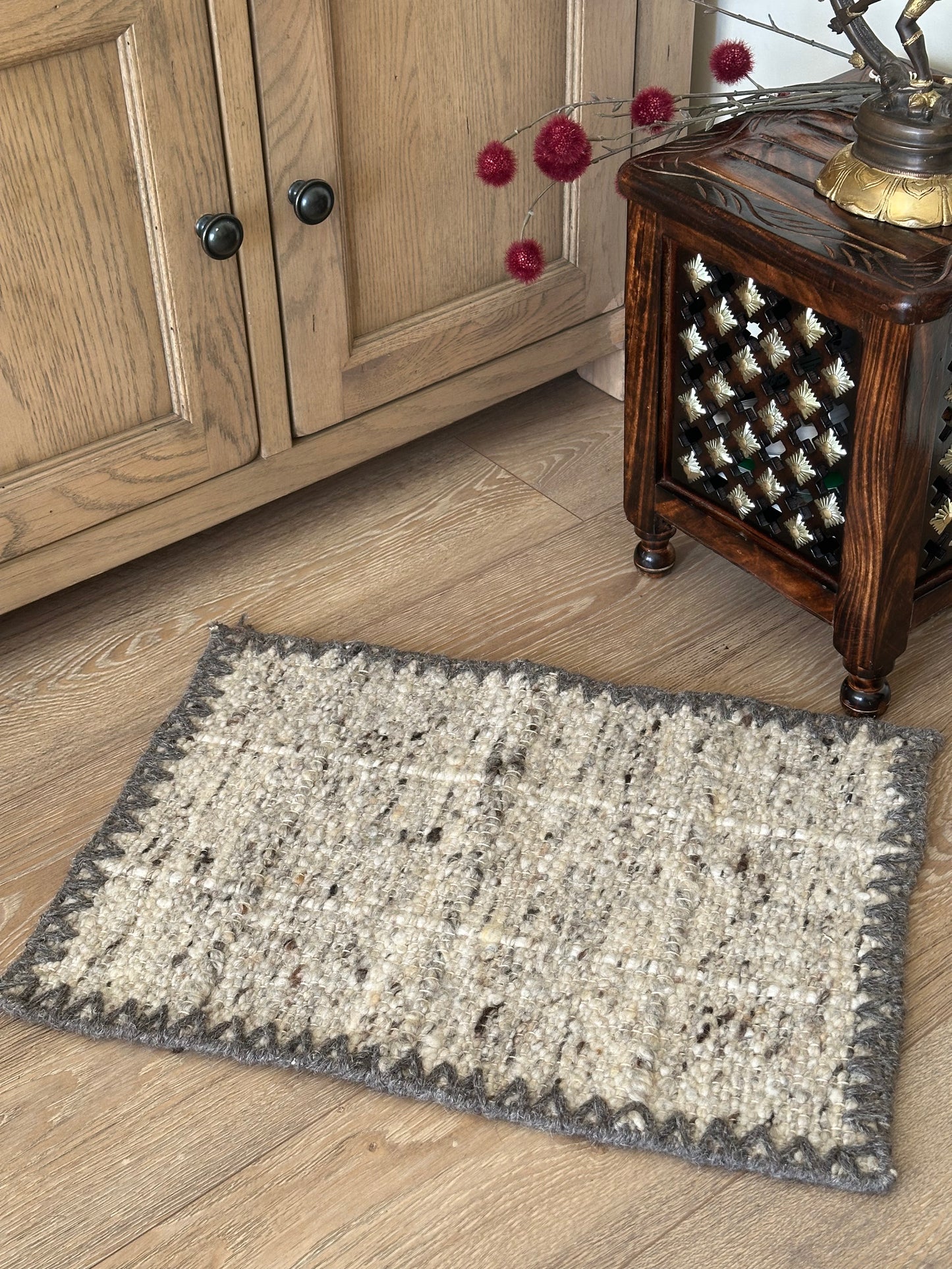 Grey border surrounding a wool cotton rug