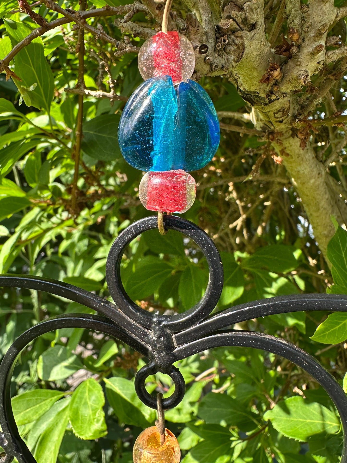 Close-up of heart wind chime with beads and brass bells