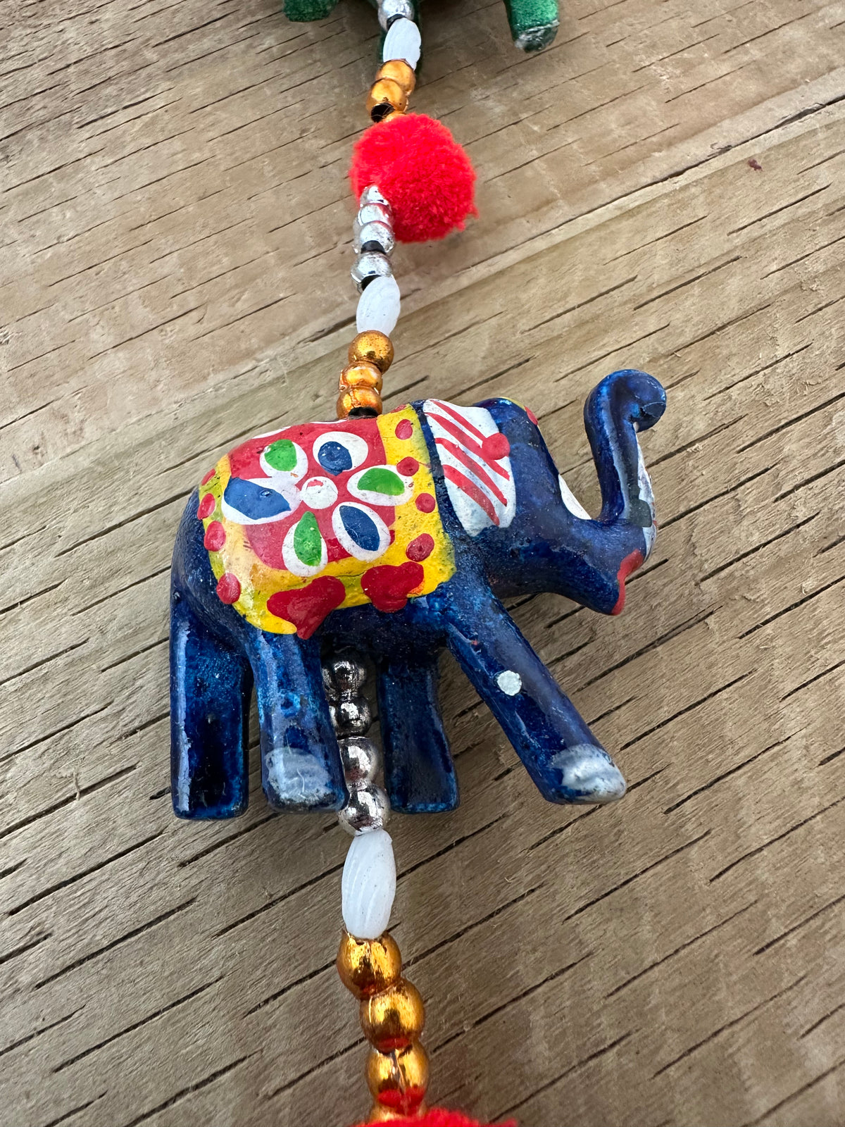 Five carved wooden elephants in bright colours