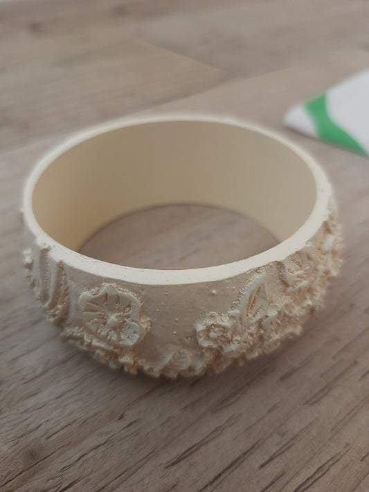 Off-white hand-engraved bangle with flowing design