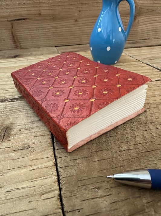 Orange mini leather notebook with embossed decorative cover