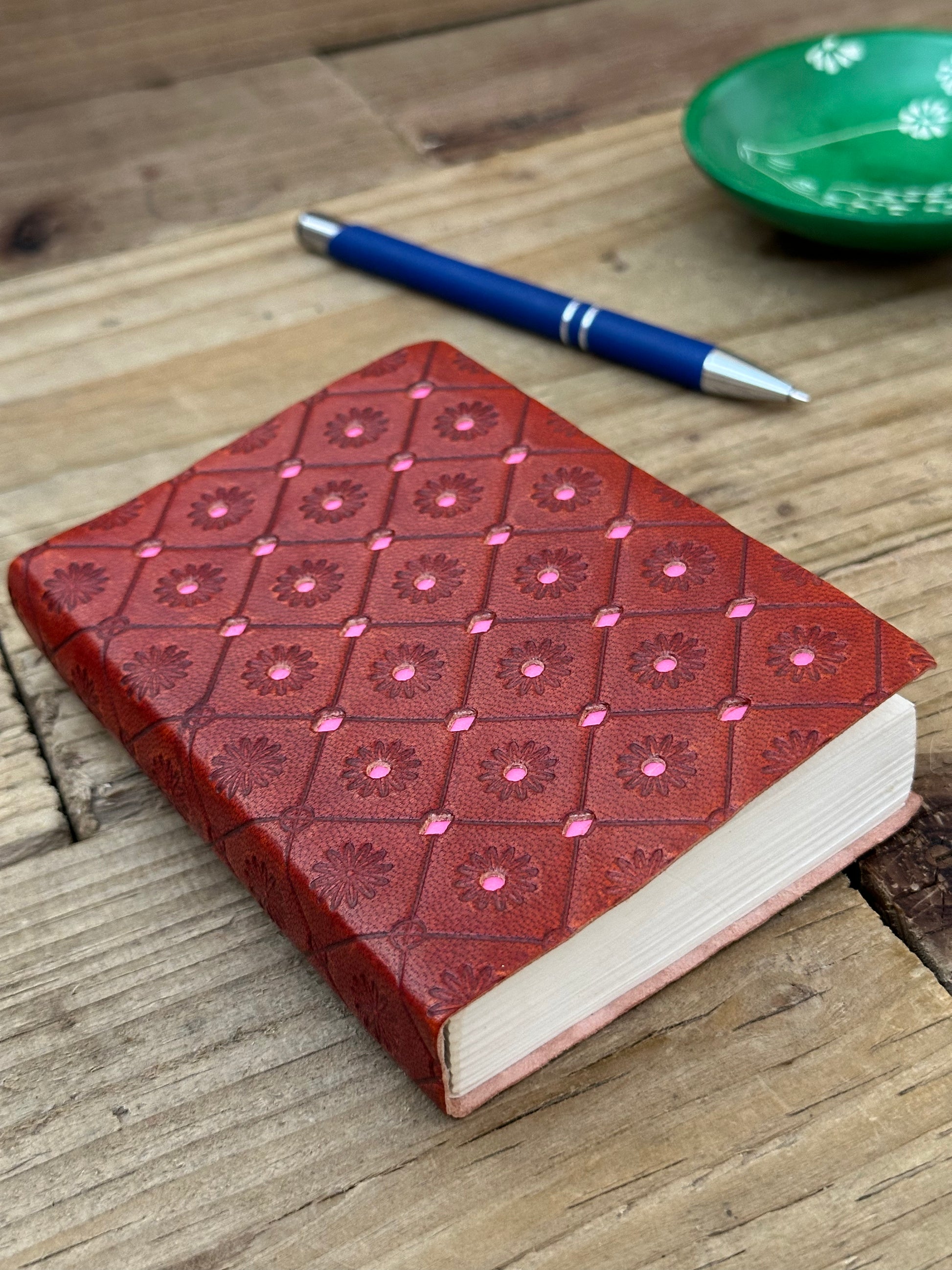 Pink mini leather notebook opened to show handmade recycled cotton paper