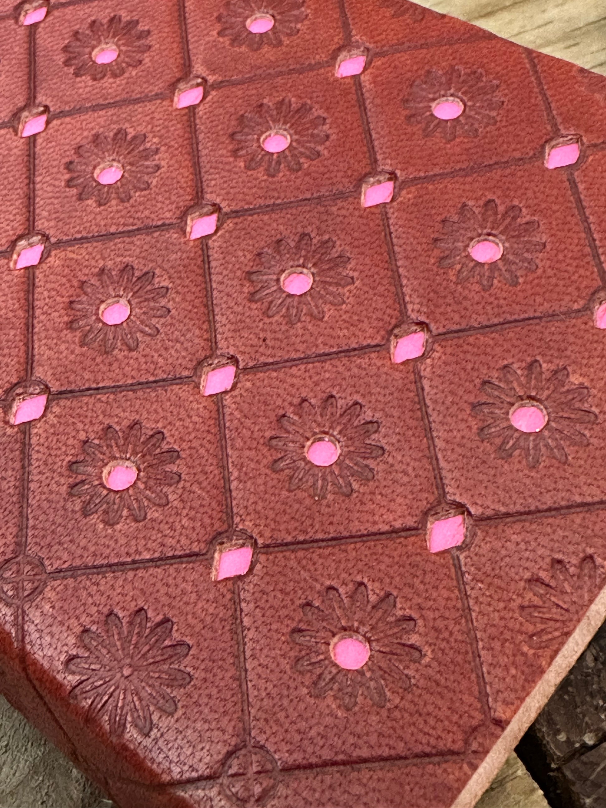 Close-up of embossed pink leather notebook cover with decorative detailing