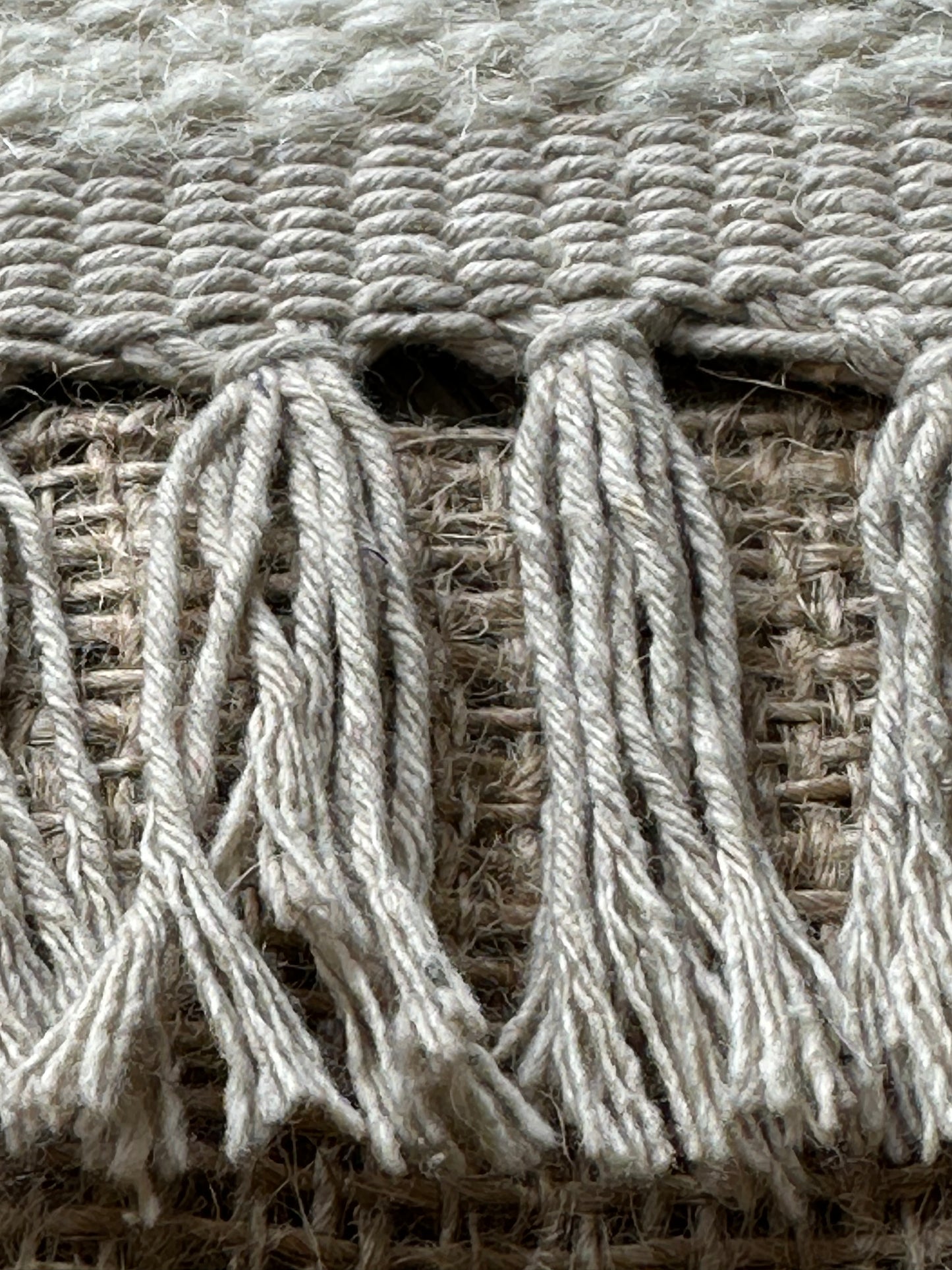 White tassels finishing a multicoloured cotton rug