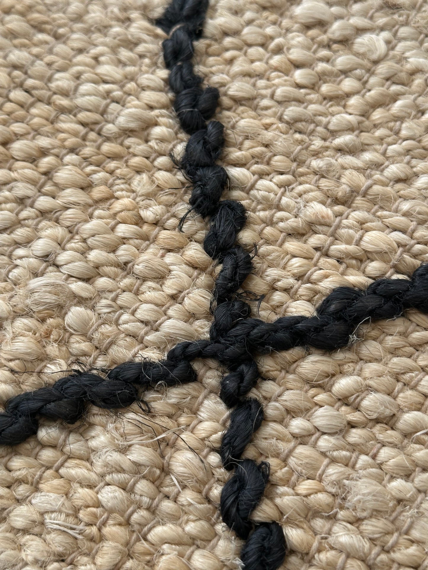 Handmade white jute rug with geometric black design